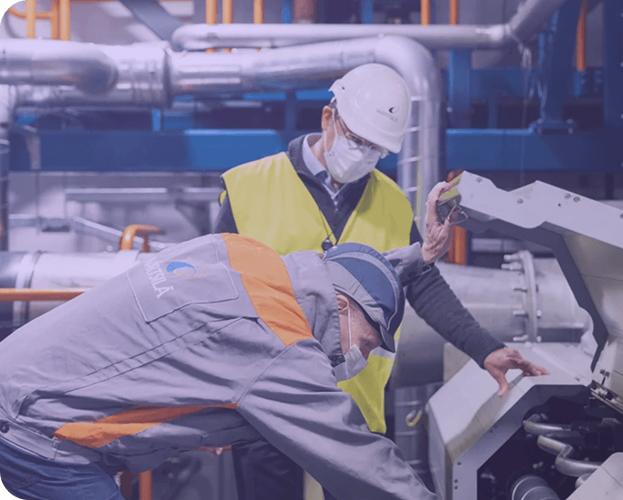 Worker in safety gear with tablet in industrial setting